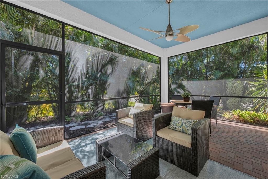13404 Monticello Boulevard Naples, FL 34109 - Photo 19 of 23 Screened lanai with ceiling fan and peaceful garden views, perfect for outdoor living.