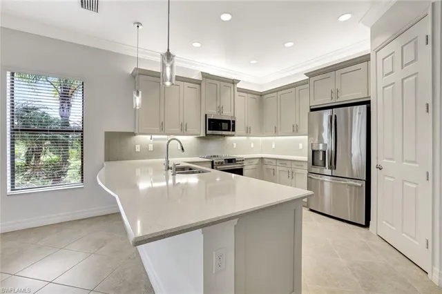 a kitchen with kitchen island a refrigerator stove and microwave