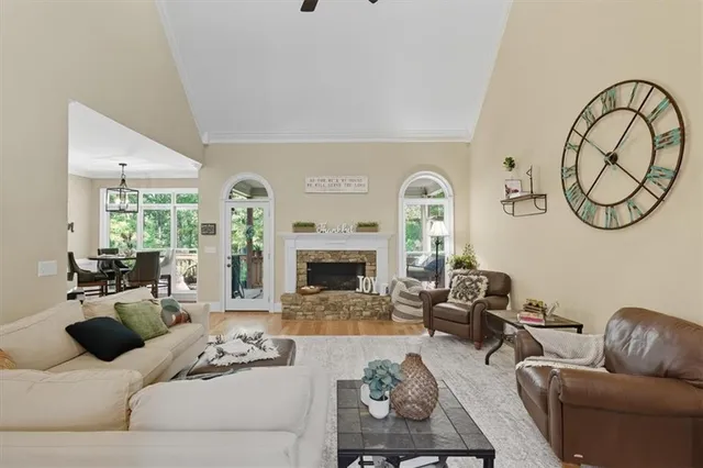 a kitchen with stainless steel appliances granite countertop white cabinets a sink a stove a refrigerator and dishwasher with wooden floor