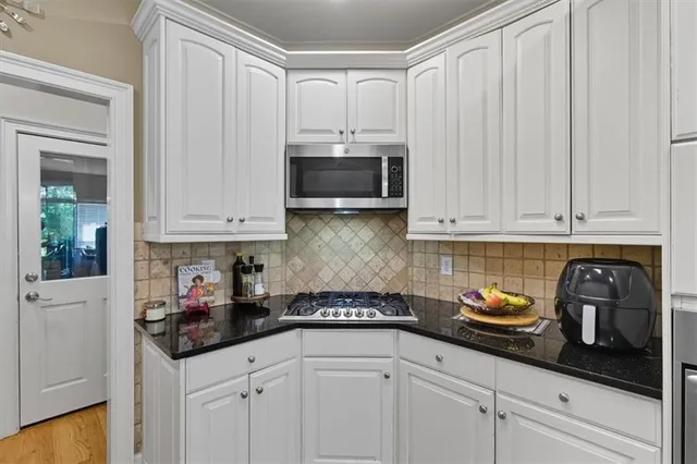 a kitchen with a dining table chairs and refrigerator