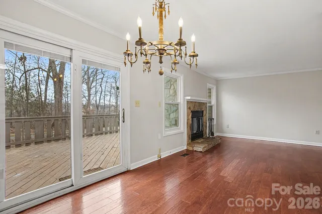 a view of a livingroom with wooden floor a ceiling fan and window
