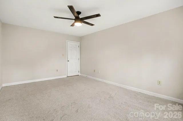 an empty room with a ceiling fan and a window