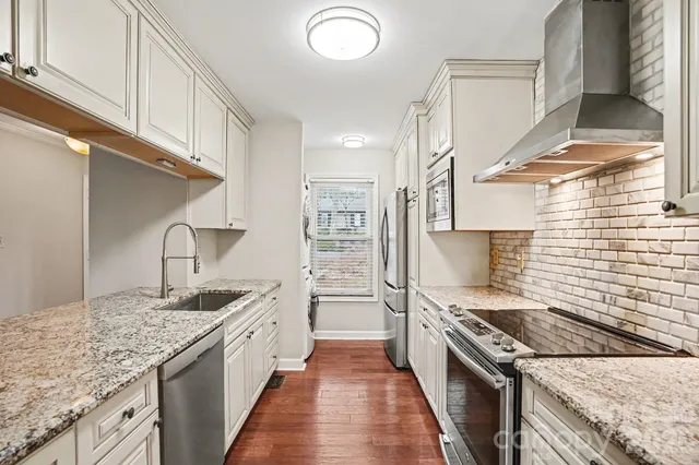 a kitchen with stainless steel appliances granite countertop a stove and a sink