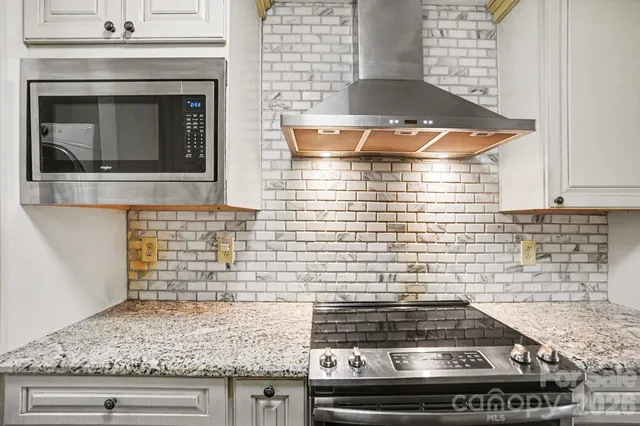 a kitchen with granite countertop cabinets and a stove top oven