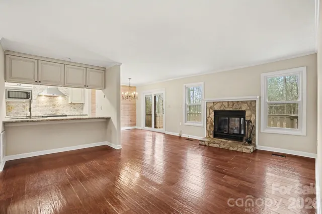 a view of empty room with wooden floor and fireplace