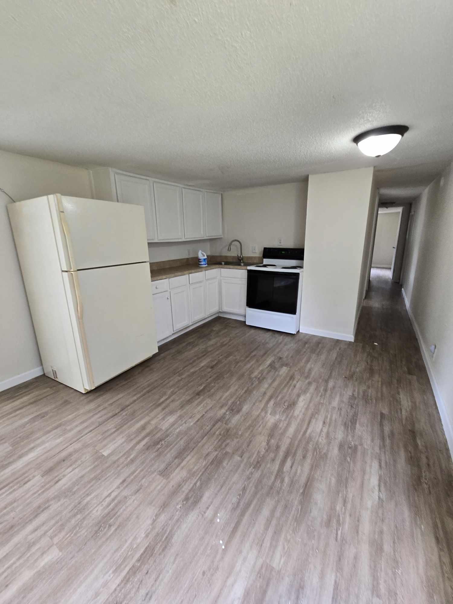 864 East Chestnut Avenue, Unit D Crestview, FL 32539 - Photo 3 of 10 a kitchen with wooden floors and white appliances