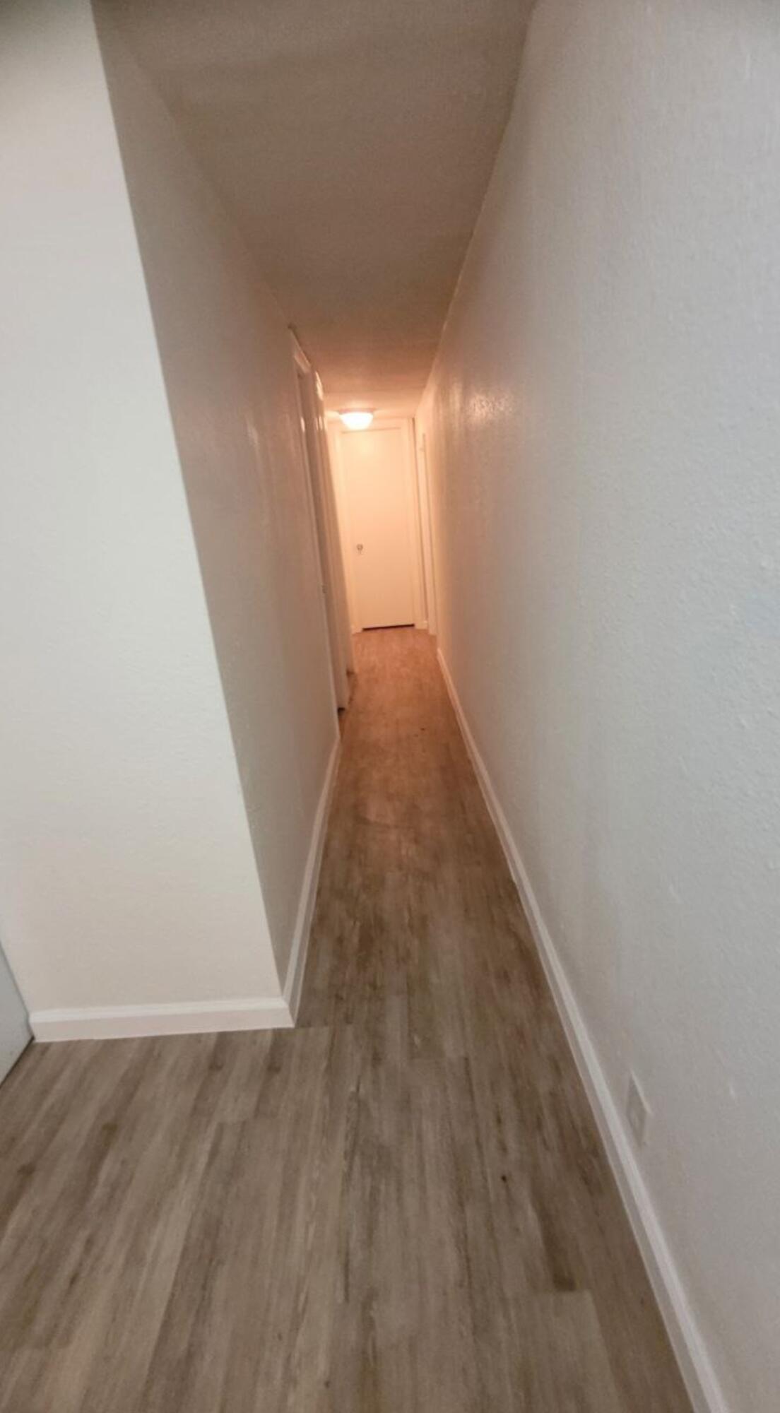 864 East Chestnut Avenue, Unit D Crestview, FL 32539 - Photo 6 of 10 a view of a hallway with wooden floor