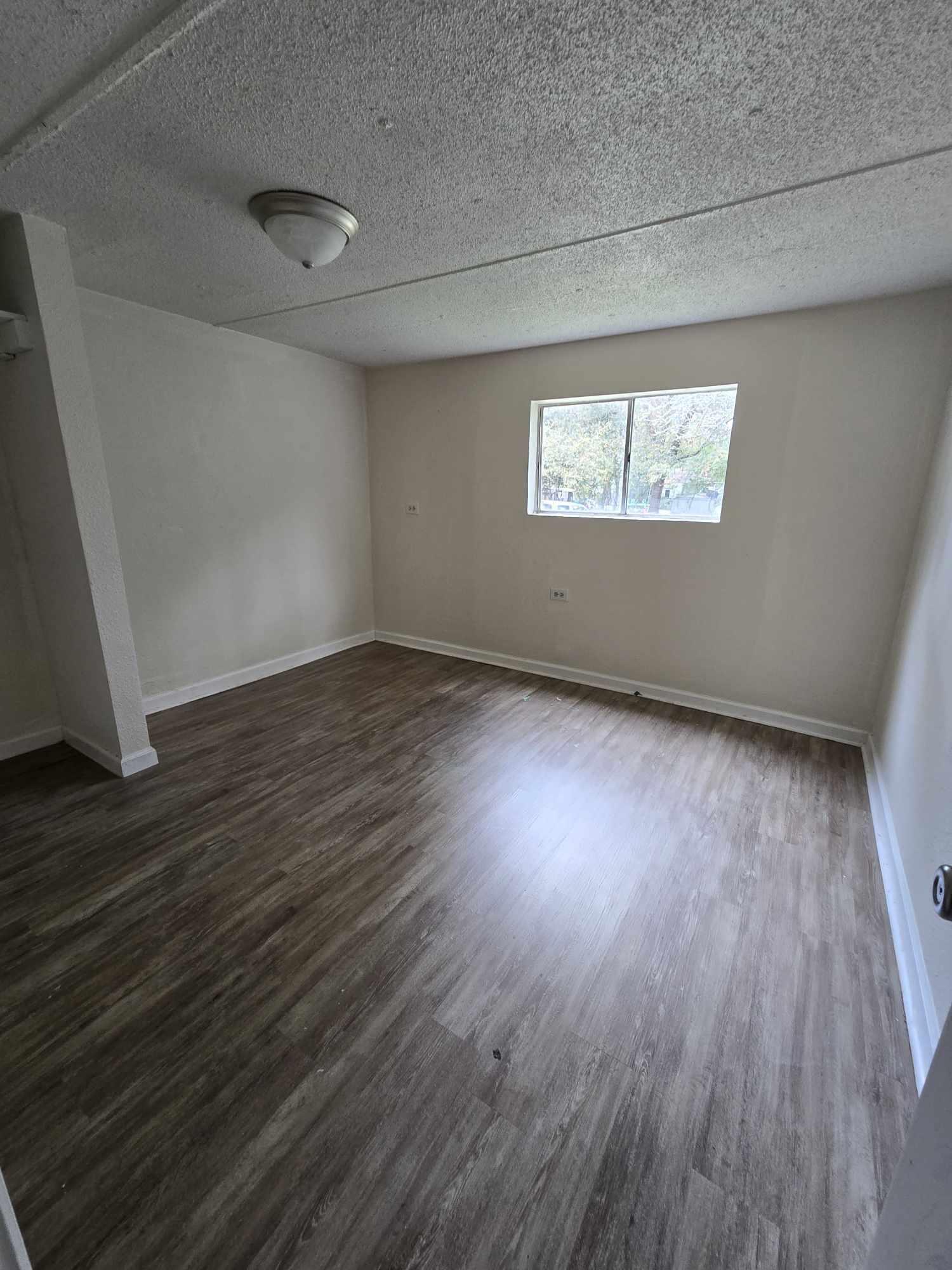 864 East Chestnut Avenue, Unit D Crestview, FL 32539 - Photo 7 of 10 an empty room with wooden floor and windows