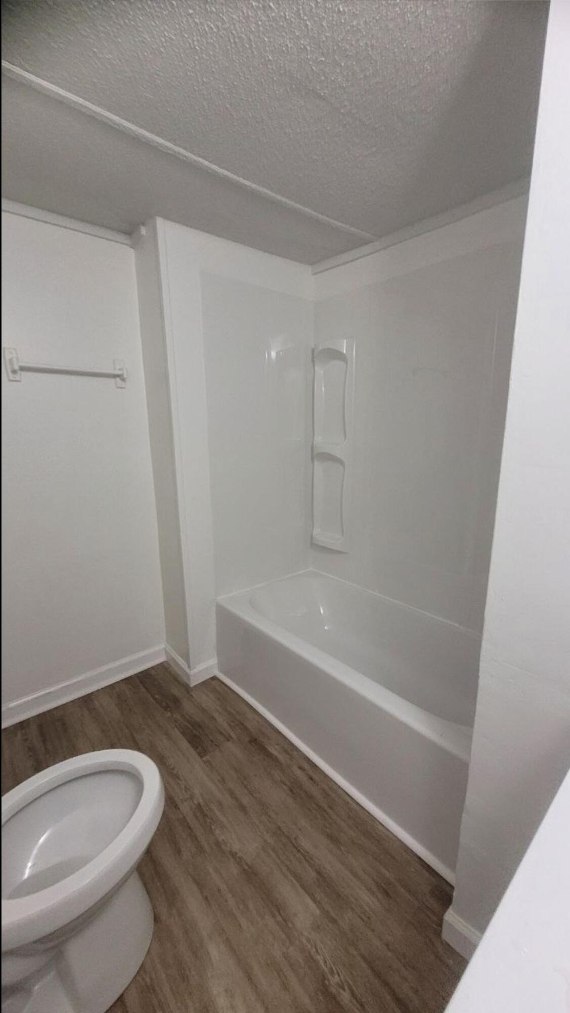 864 East Chestnut Avenue, Unit D Crestview, FL 32539 - Photo 8 of 10 a bathroom with a granite countertop bathtub shower and toilet