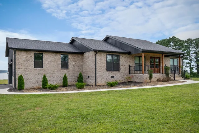 a front view of a house with a garden and plants