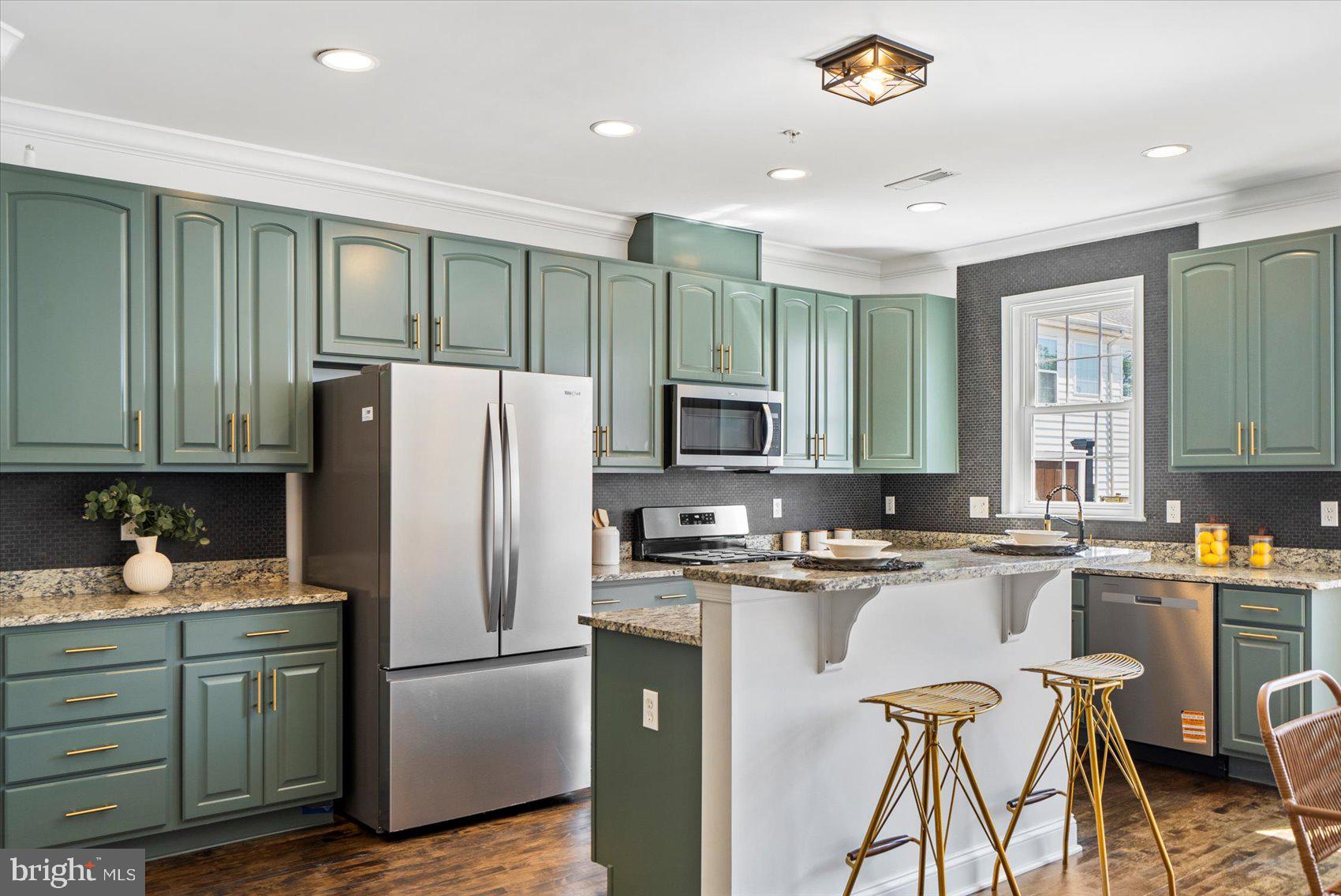 829 McHenry Street Baltimore, MD 21230 - Photo 16 of 41 a kitchen with stainless steel appliances granite countertop a refrigerator a sink dishwasher a stove and white cabinets with wooden floor