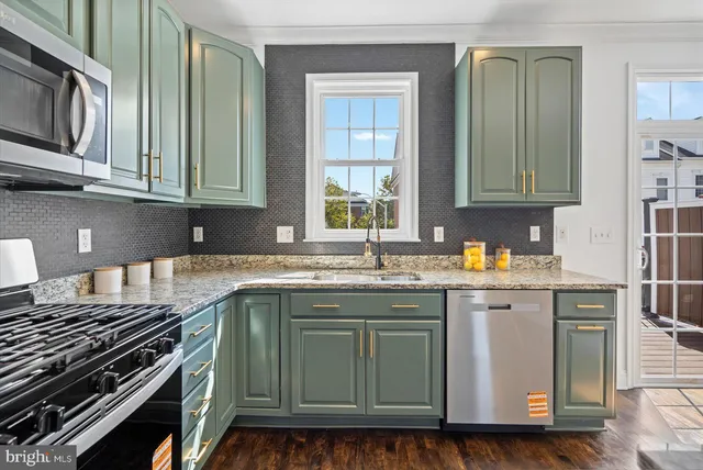 a kitchen with stainless steel appliances granite countertop a stove a sink and a microwave