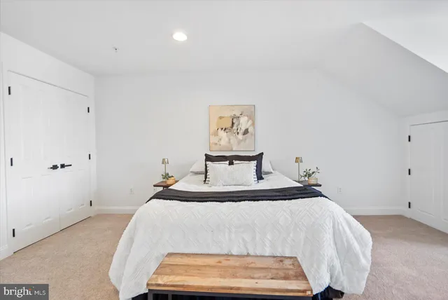 a hallway with painting on the wall and a potted plant