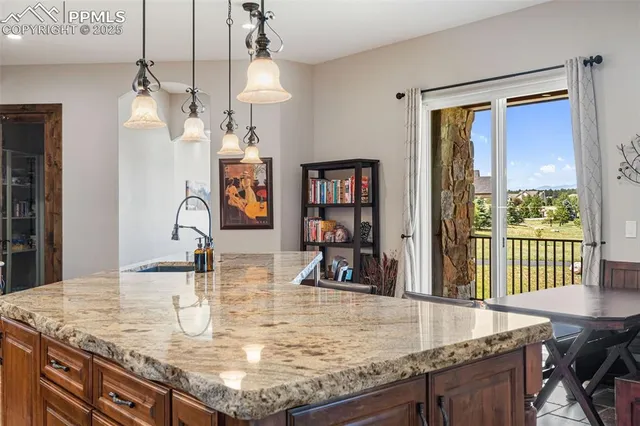 a kitchen with granite countertop a sink a counter top space and living room view