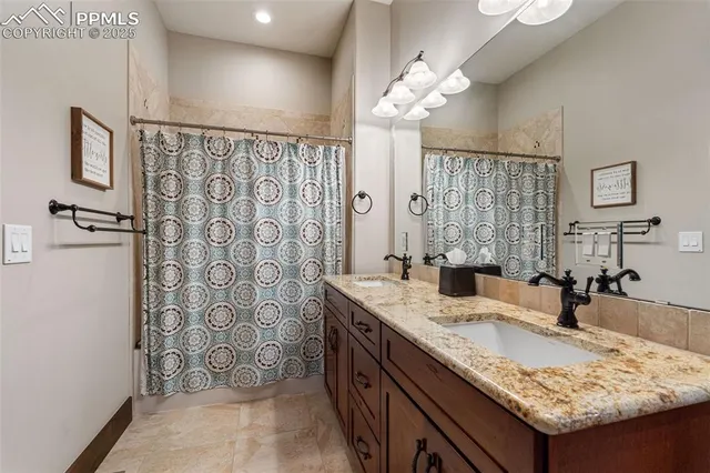 a bathroom with a granite countertop double vanity sink and a mirror