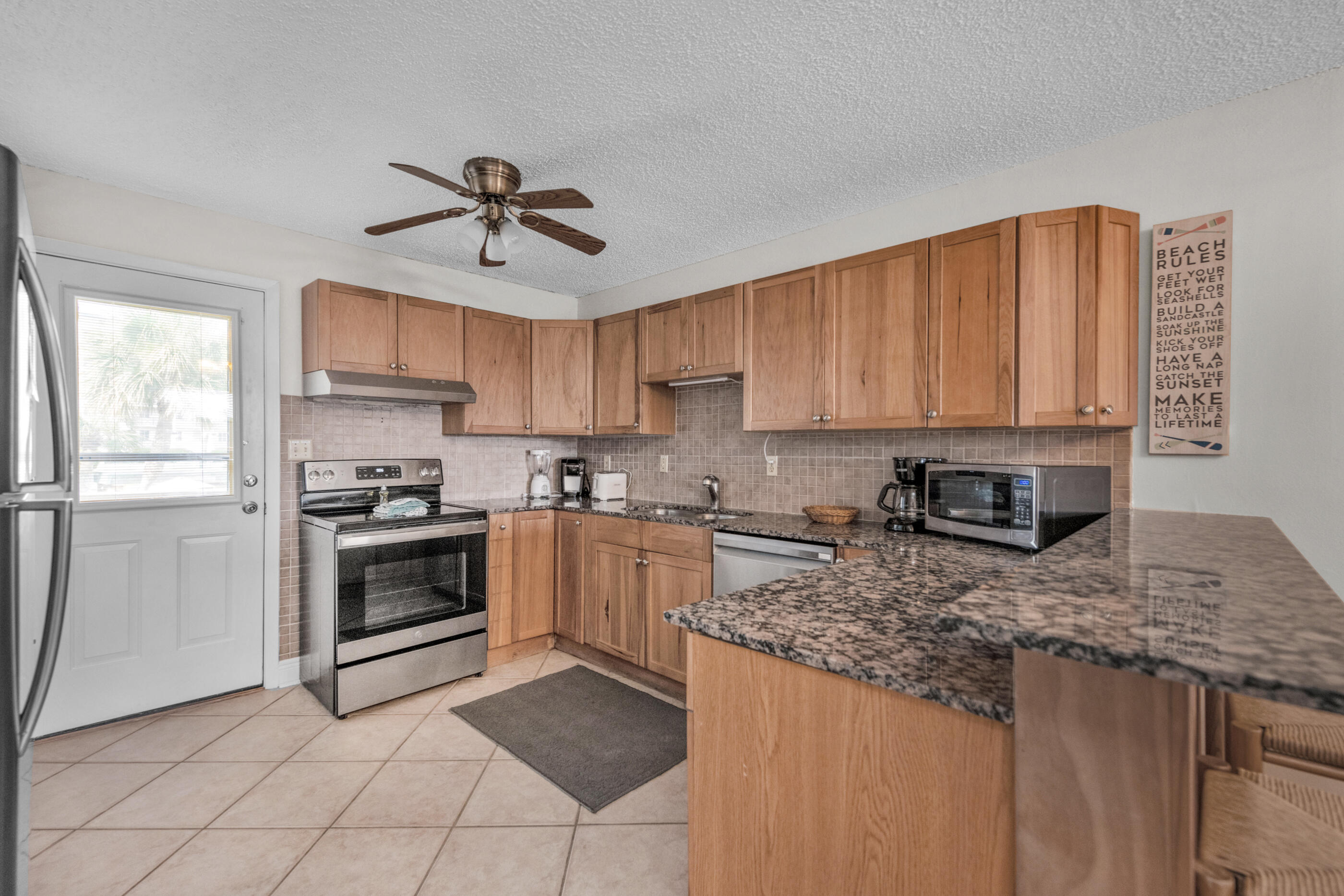 885 Santa Rosa Boulevard, Unit 208 Fort Walton Beach, FL 32548 - Photo 10 of 15 a kitchen with stainless steel appliances granite countertop a stove a sink and a refrigerator