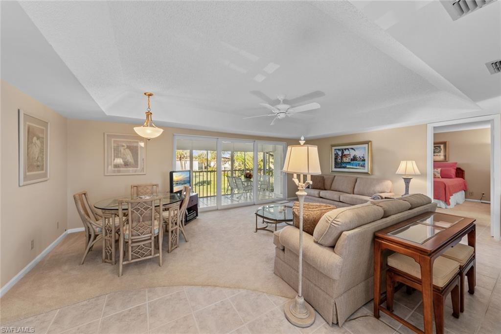 273 Albi Road, Unit 4 Naples, FL 34112 - Photo 11 of 50 Carpeted living room with ceiling fan, a raised ceiling, and a textured ceiling