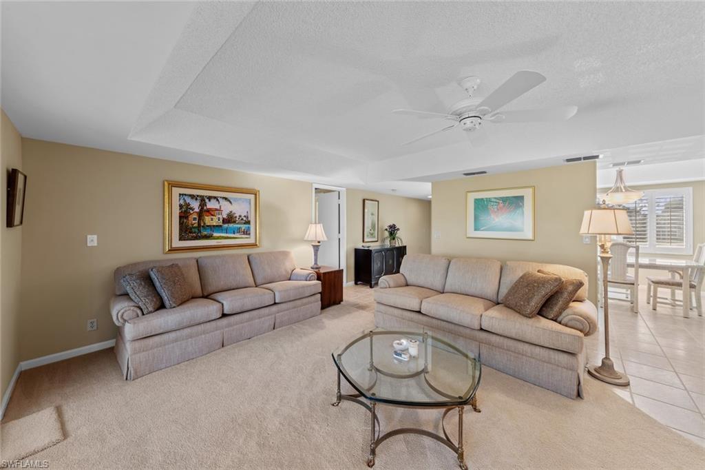 273 Albi Road, Unit 4 Naples, FL 34112 - Photo 12 of 50 Tiled living room featuring ceiling fan and a textured ceiling