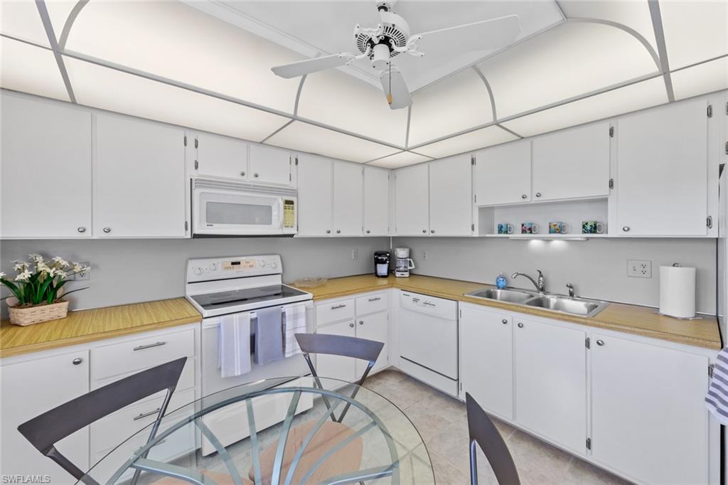 273 Albi Road, Unit 4 Naples, FL 34112 - Photo 13 of 50 Kitchen featuring ceiling fan, white cabinetry, white appliances, and sink