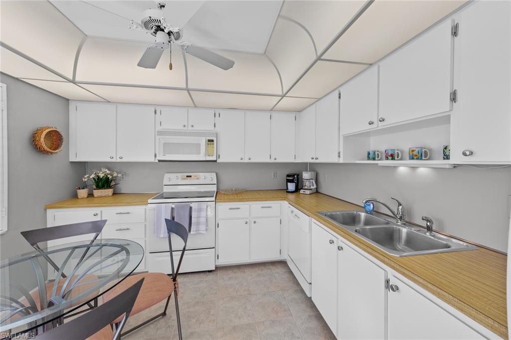 273 Albi Road, Unit 4 Naples, FL 34112 - Photo 15 of 50 Kitchen featuring white cabinets, white appliances, ceiling fan, and sink