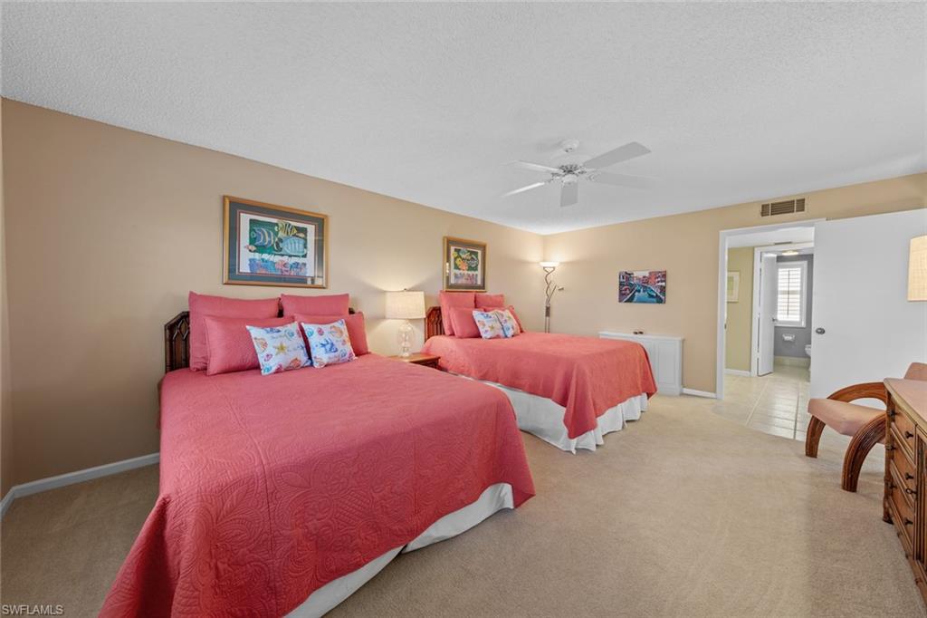 273 Albi Road, Unit 4 Naples, FL 34112 - Photo 26 of 50 Bedroom with ceiling fan, light colored carpet, and a textured ceiling