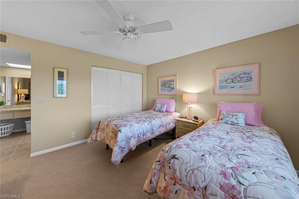 273 Albi Road, Unit 4 Naples, FL 34112 - Photo 30 of 50 Carpeted bedroom with ceiling fan, a closet, and a textured ceiling