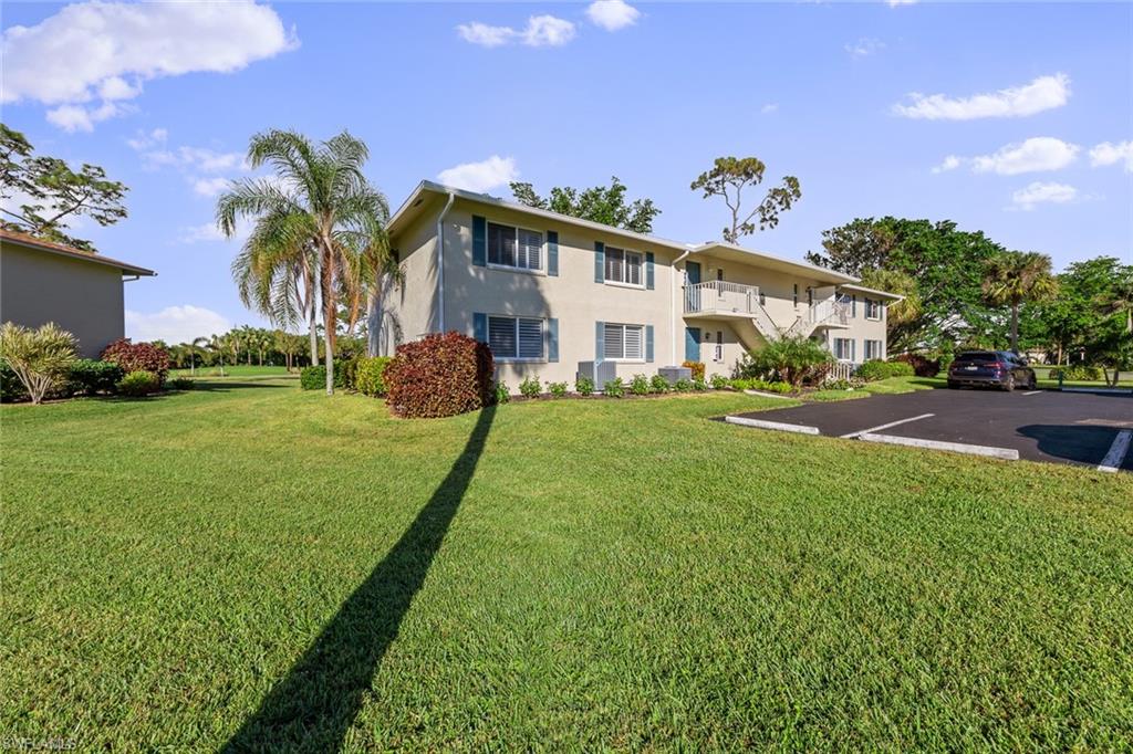 273 Albi Road, Unit 4 Naples, FL 34112 - Photo 35 of 50 View of front facade featuring a front yard