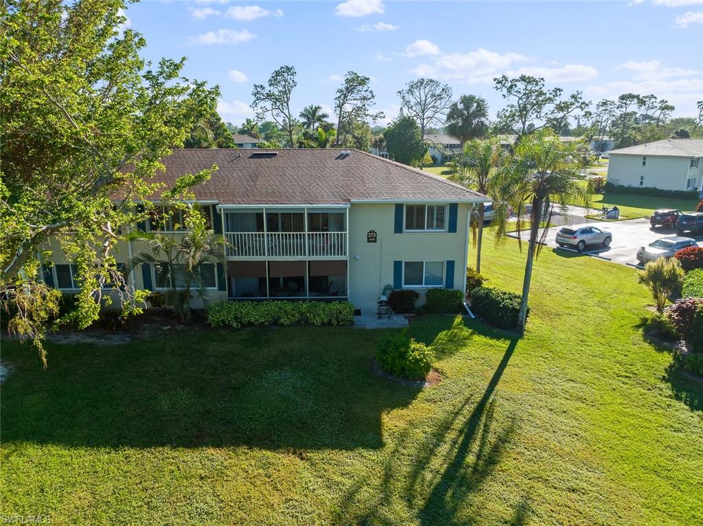 273 Albi Road, Unit 4 Naples, FL 34112 - Photo 39 of 50 Back of property featuring a lanai and a yard