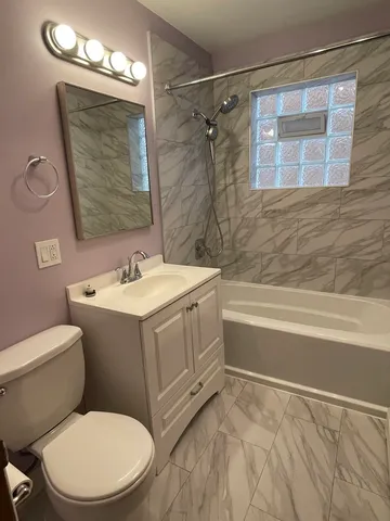 a bathroom with a sink vanity mirror and toilet