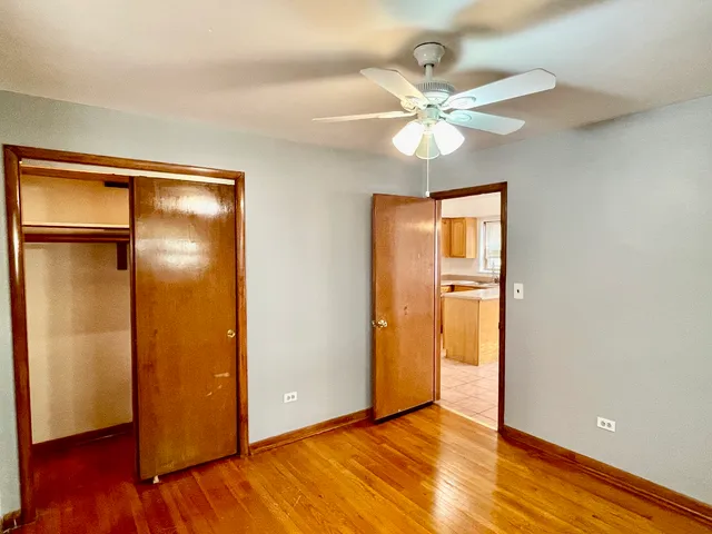 a view of a room with window a ceiling fan and wooden floor