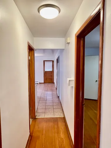 a view of a hallway with wooden floor and glass door