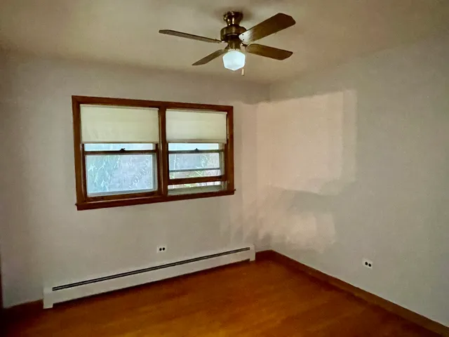 an empty room with a window and a fan