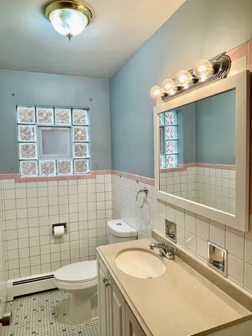 a bathroom with a sink a toilet and mirror