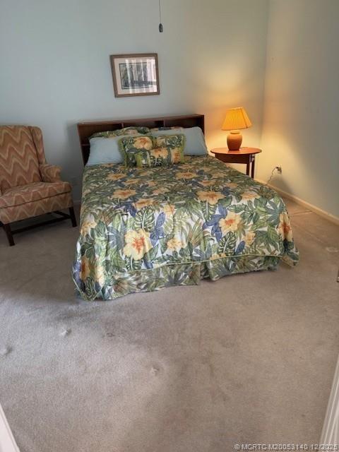 3480 Southeast Martinique Trace, Unit 102 Stuart, FL 34997 - Photo 17 of 24 a bed sitting in a bedroom next to a couch