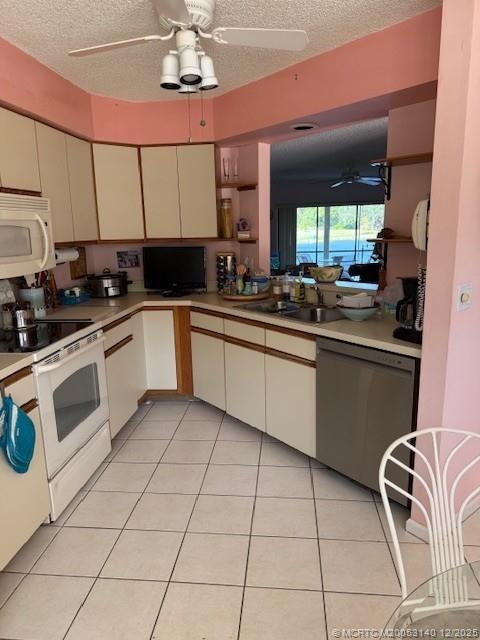 3480 Southeast Martinique Trace, Unit 102 Stuart, FL 34997 - Photo 9 of 24 a kitchen with stainless steel appliances granite countertop a sink and cabinets