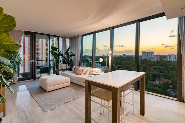 a living room with a large window and furniture