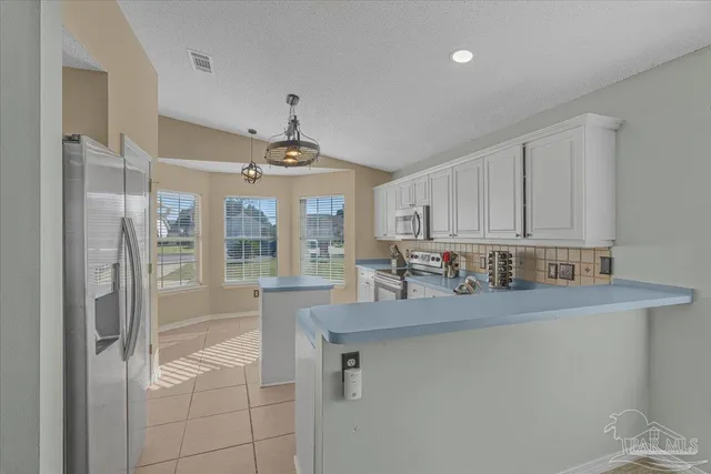 a kitchen with stainless steel appliances granite countertop a sink and a refrigerator