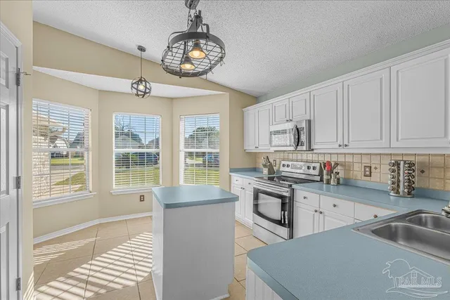 a kitchen with stainless steel appliances granite countertop a sink dishwasher stove and refrigerator