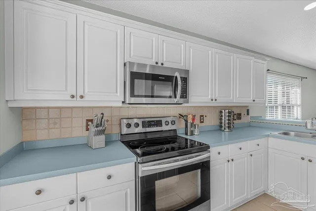 a kitchen with white cabinets and white appliances