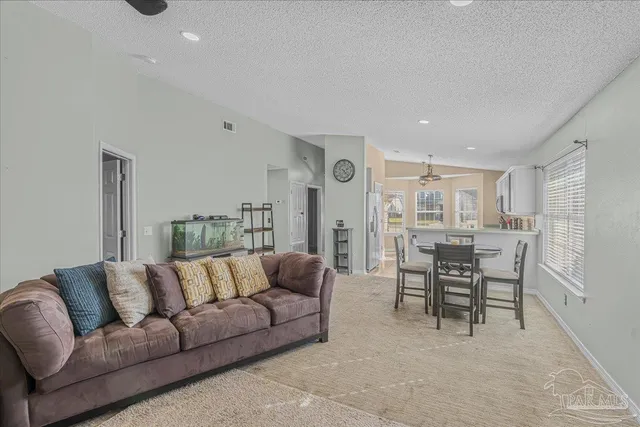 a living room with furniture and a dining table with kitchen view