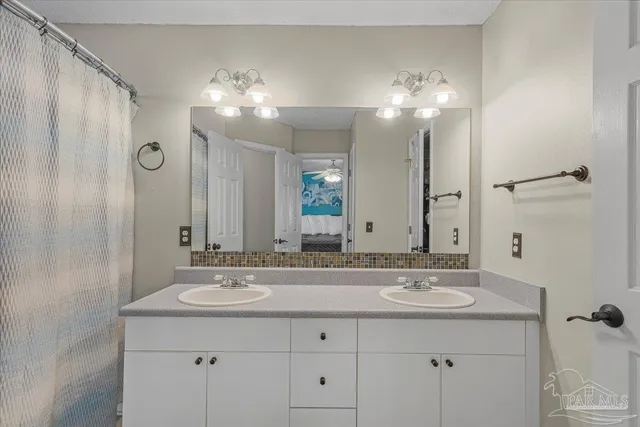 a bathroom with double vanity and a mirror