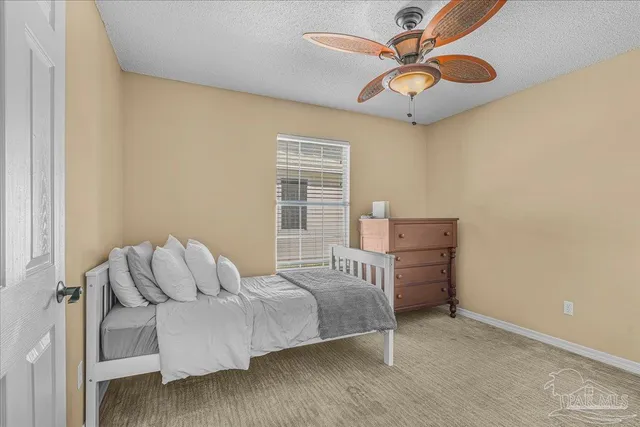 a bedroom with a bed a window and a chandelier