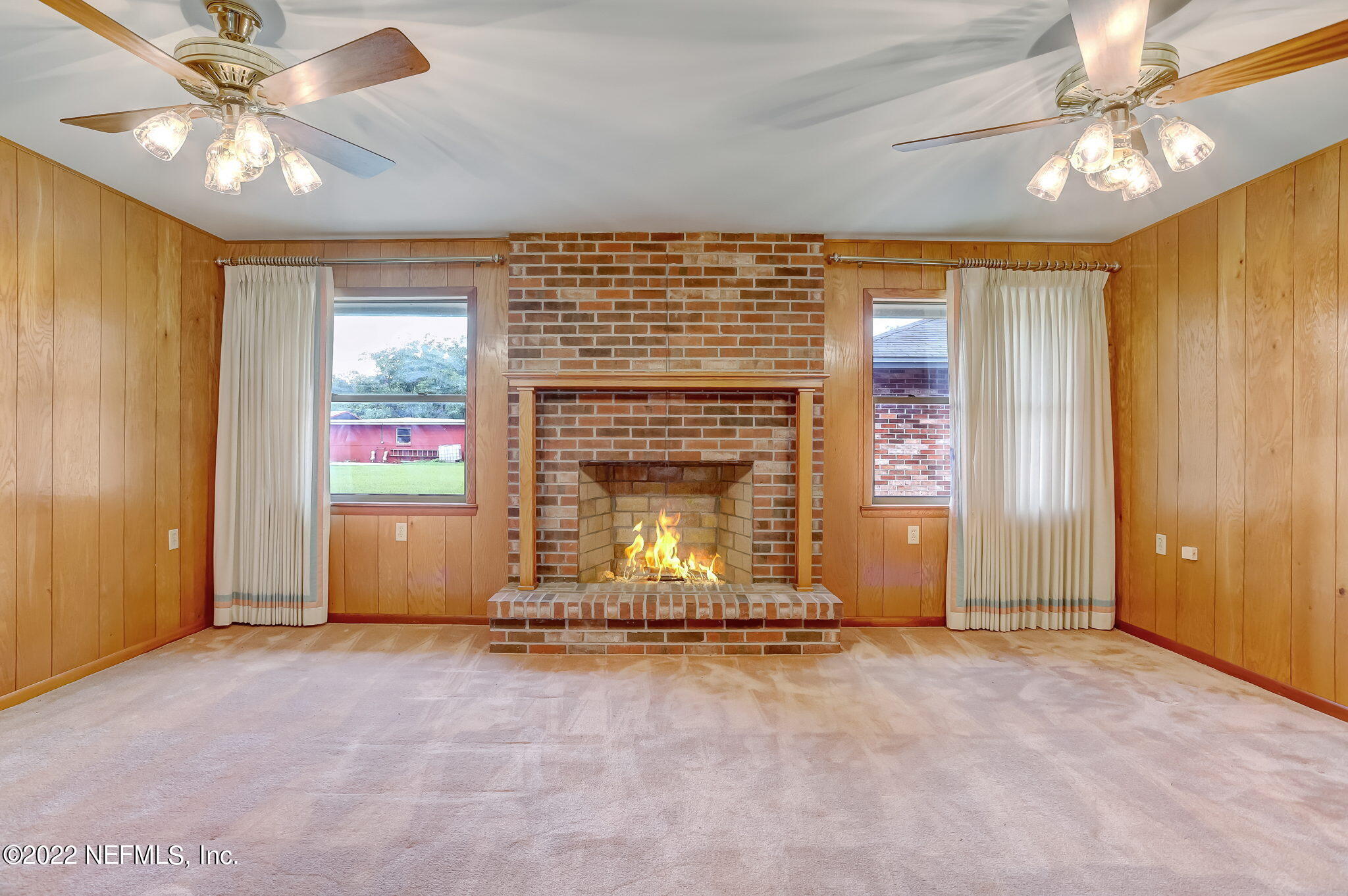 11643 Olde Mandarin Road Jacksonville, FL 32223 - Photo 29 of 70 an empty room with fireplace chandelier fan and windows
