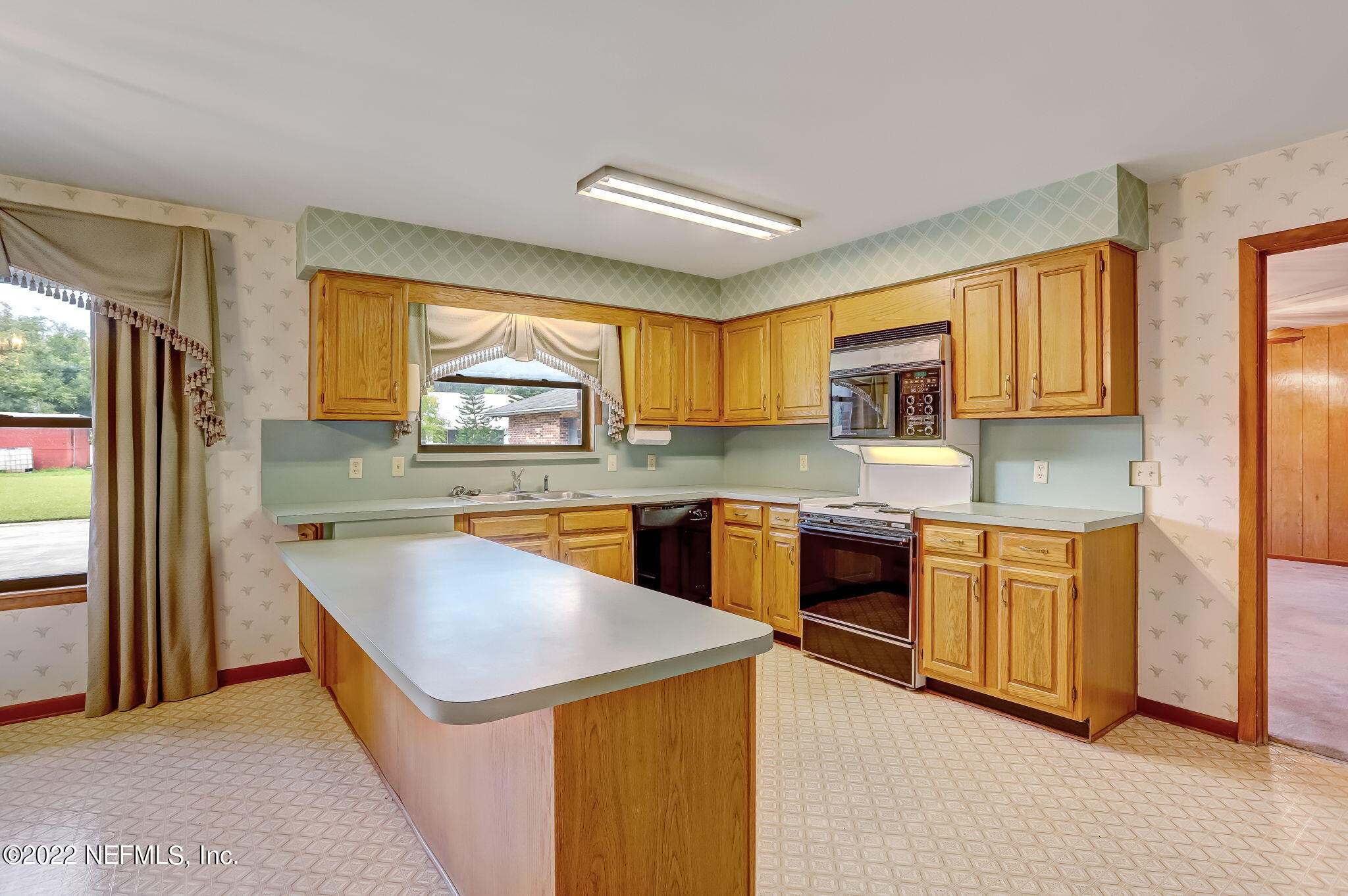 11643 Olde Mandarin Road Jacksonville, FL 32223 - Photo 31 of 70 a kitchen with stainless steel appliances granite countertop wooden cabinets a sink a stove a refrigerator a microwave oven with cabinets and wooden floor