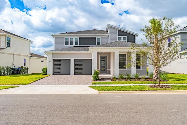 a front view of a house with garden and yard