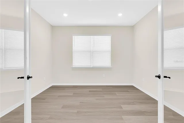 an empty room with wooden floor and a window