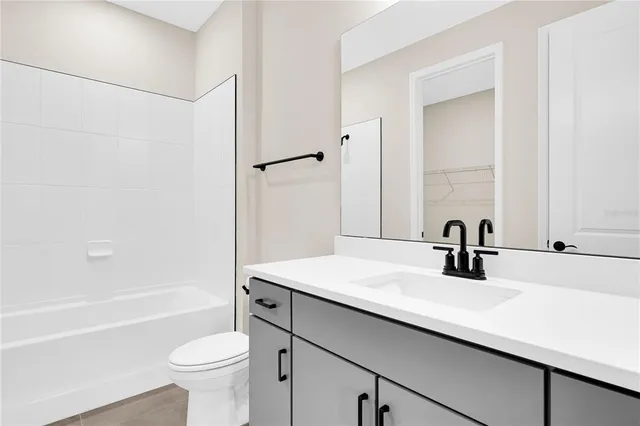 a bathroom with a sink a toilet a mirror and bathtub