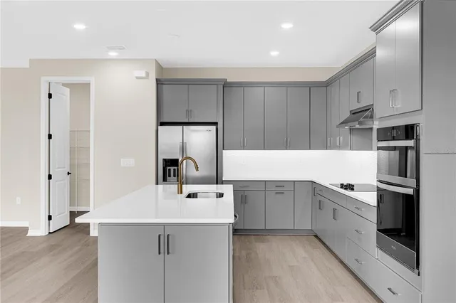 a kitchen with a sink stainless steel appliances and cabinets