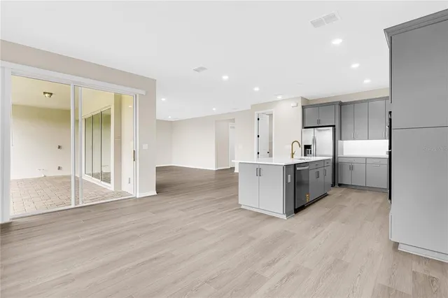 a large kitchen with stainless steel appliances granite countertop a large counter top and a wooden floors