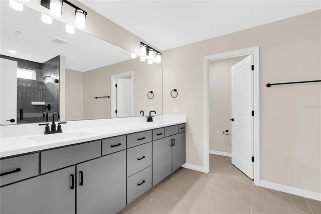 a bathroom with double sink and a mirror
